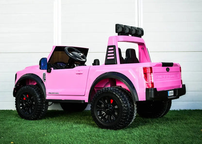 Kids ride on pink Ford Super Duty truck with black wheels, plush seats, and a roll bar on grass backdrop.