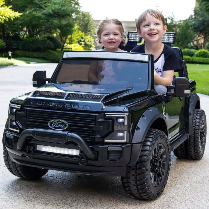 Kids enjoying a ride in a Ford Super Duty ride-on truck, featuring two seats and stylish design in an outdoor setting.